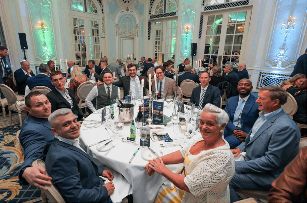 Elegant business event in a luxurious ballroom with professionals enjoying a formal dinner.