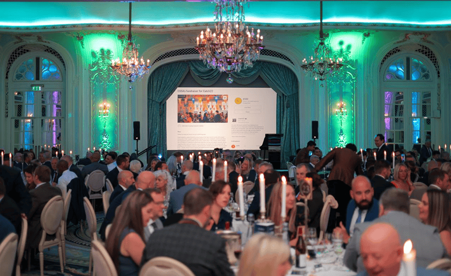 Elegant banquet hall with green lighting and chandeliers at a formal event in Essex.