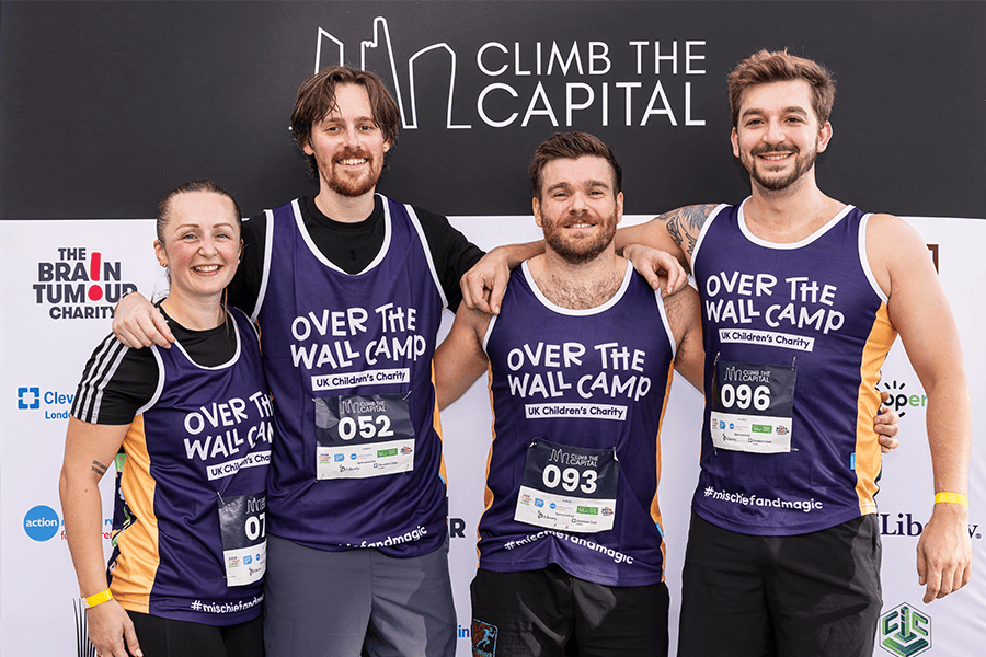 Group of four smiling participants at Over The Wall Camp charity event.