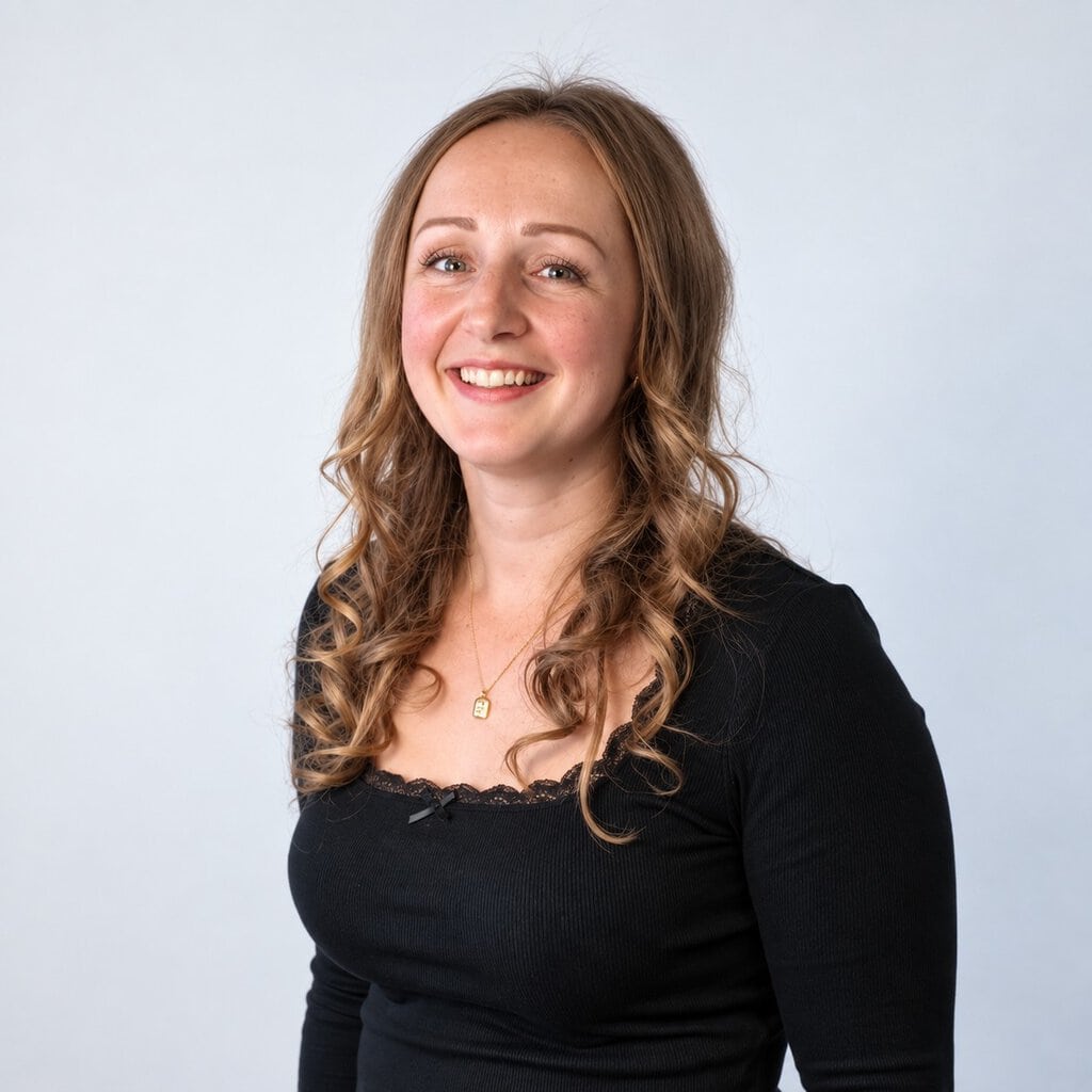 Smiling woman with wavy hair in black top for about us section.