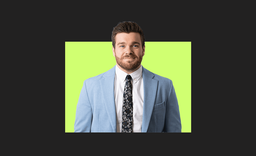 Portrait of a man in a light blue suit and patterned tie against a green background.
